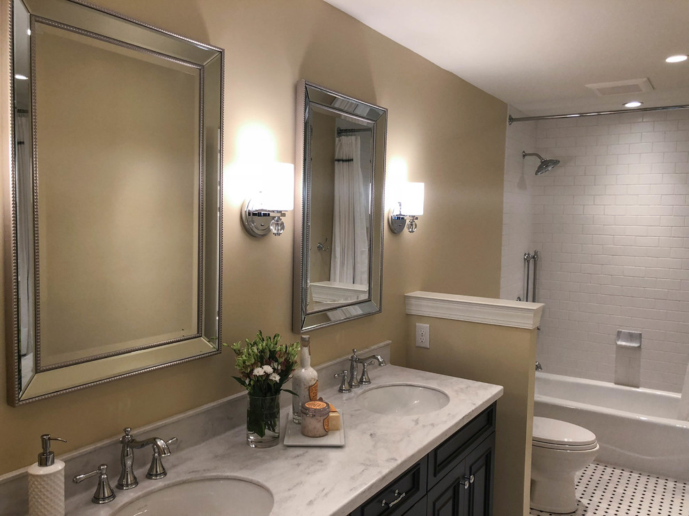 Photo of a small transitional bathroom in Philadelphia with shaker cabinets, black cabinets, a shower/bathtub combo, a one-piece toilet, white tile, an integrated sink, marble benchtops, multi-coloured floor, a shower curtain, multi-coloured benchtops, a double vanity and a freestanding vanity.