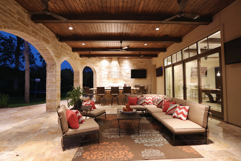 Photo of an expansive mediterranean backyard patio in Houston with an outdoor kitchen, natural stone pavers and a roof extension.