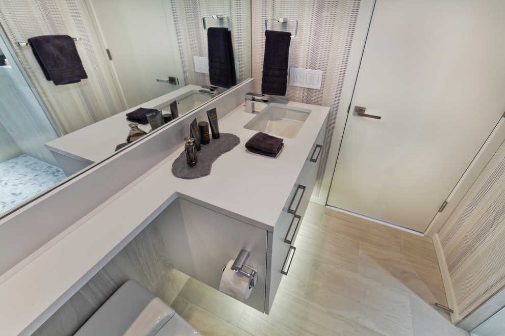 Design ideas for a small contemporary 3/4 bathroom in Minneapolis with an undermount sink, flat-panel cabinets, white cabinets, engineered quartz benchtops, a one-piece toilet, gray tile, glass tile, multi-coloured walls and porcelain floors.