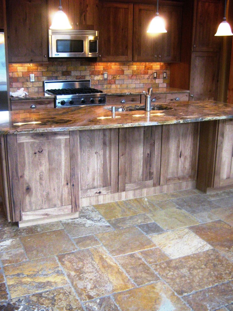 Mountain style kitchen photo in Seattle with an undermount sink, granite countertops, stone tile backsplash and an island