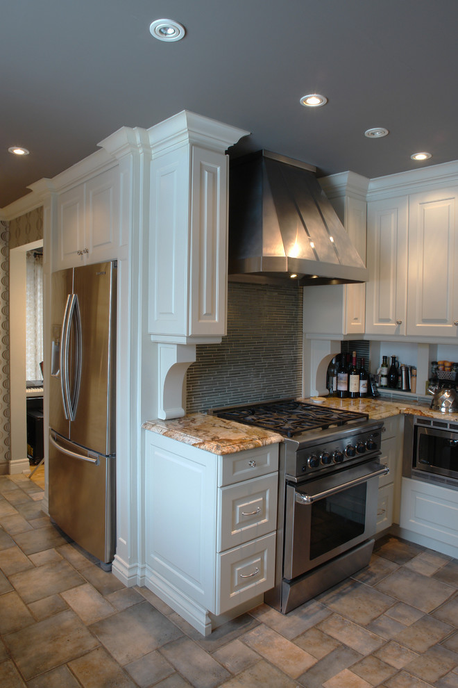 Photo of a large traditional l-shaped separate kitchen in Montreal with an undermount sink, raised-panel cabinets, white cabinets, granite benchtops, blue splashback, glass tile splashback, stainless steel appliances, terra-cotta floors and a peninsula.