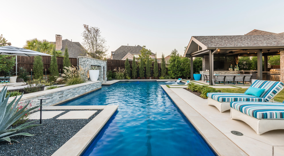 This is an example of a large transitional backyard custom-shaped lap pool in Dallas with concrete slab and a water feature.