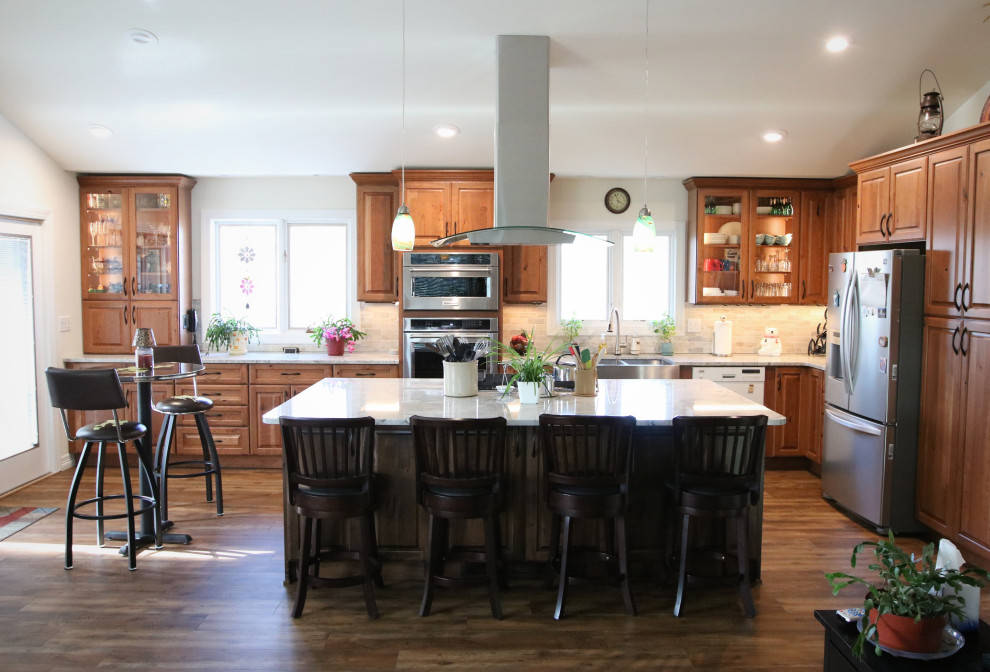 Huge elegant l-shaped vinyl floor and brown floor eat-in kitchen photo in Other with a farmhouse sink, brown cabinets, granite countertops, multicolored backsplash, marble backsplash, stainless steel appliances, an island and white countertops