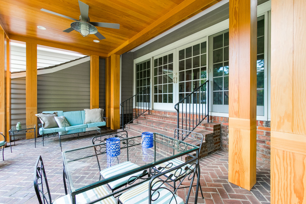 Exempel på en mellanstor modern veranda längs med huset, med marksten i tegel