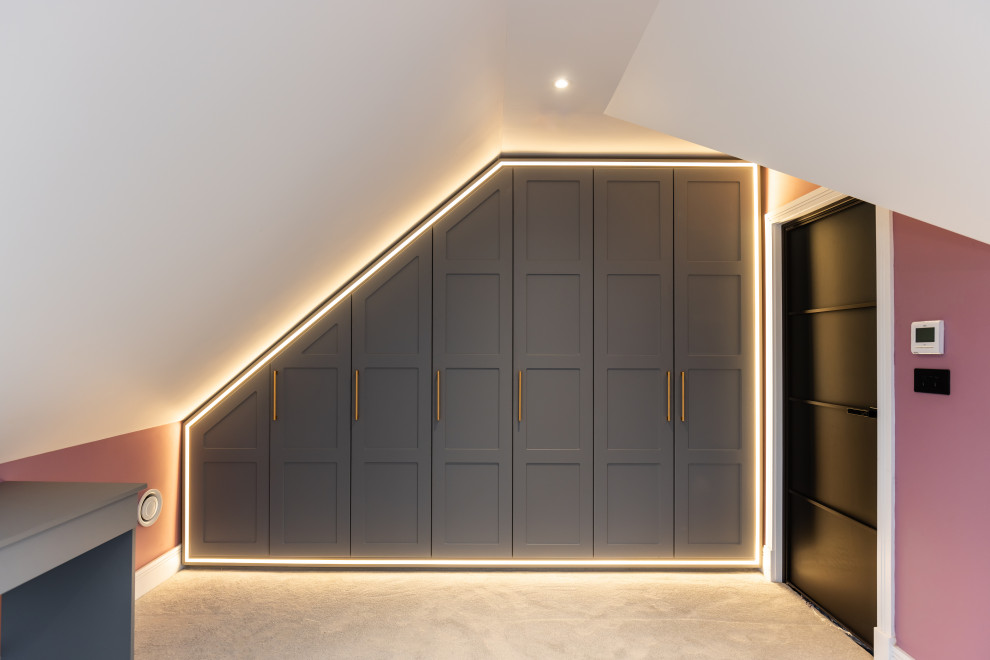 Mittelgroßes, Neutrales Modernes Ankleidezimmer mit Einbauschrank, Schrankfronten im Shaker-Stil, grauen Schränken, Teppichboden und beigem Boden in Buckinghamshire