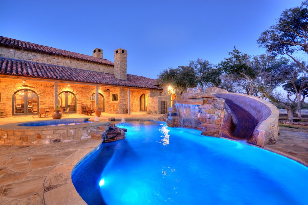 Inspiration for a rustic backyard stone and custom-shaped natural water slide remodel in Austin