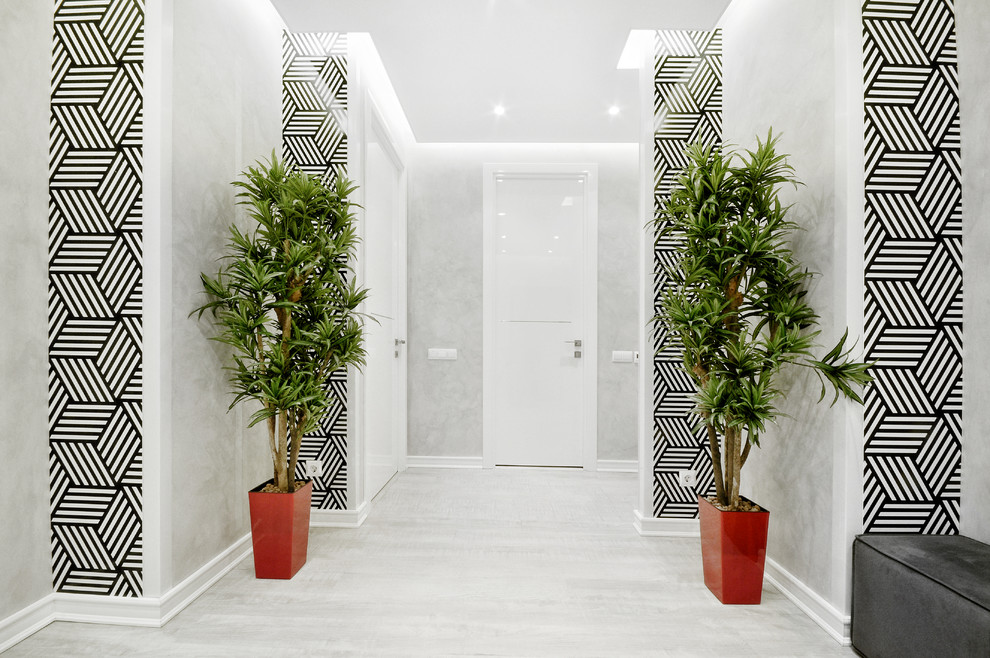 Contemporary hallway in Other with white walls, light hardwood floors and white floor.