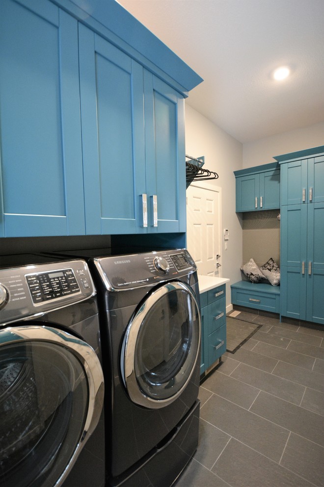 Inspiration for a mid-sized transitional single-wall dedicated laundry room in Calgary with an undermount sink, shaker cabinets, blue cabinets, quartz benchtops, grey walls, porcelain floors, a side-by-side washer and dryer and grey floor.