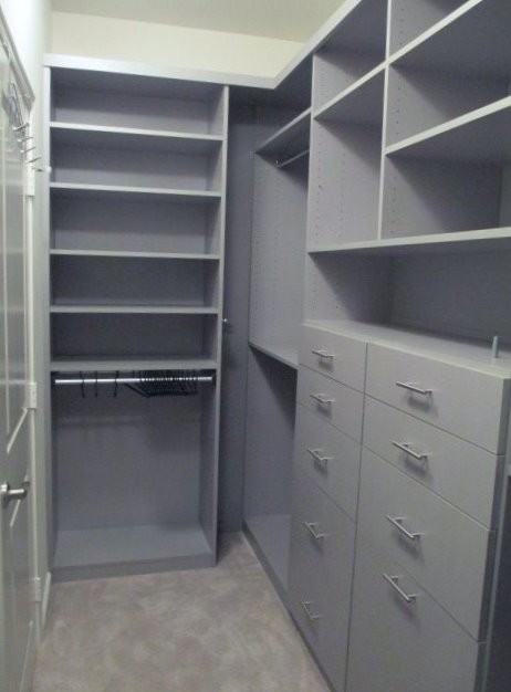 Small modern gender-neutral walk-in wardrobe in Los Angeles with flat-panel cabinets, grey cabinets, carpet and beige floor.