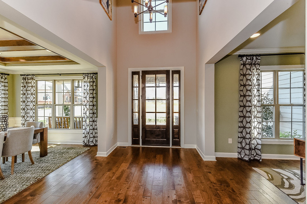 Foyer - mid-sized transitional medium tone wood floor foyer idea in Charlotte with gray walls and a medium wood front door
