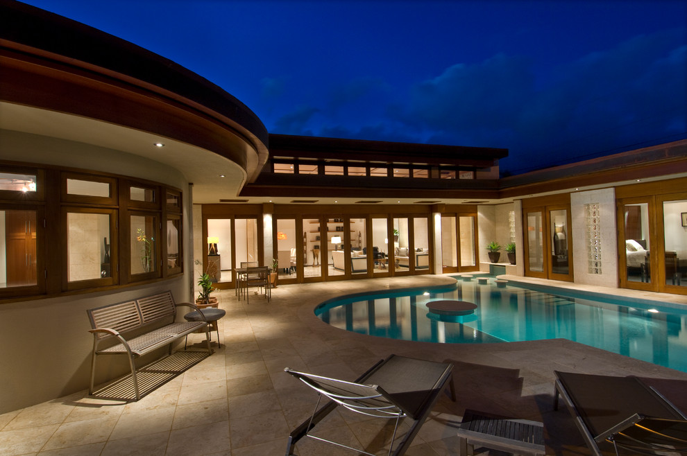 Inspiration for a mid-sized contemporary courtyard custom-shaped pool in Hawaii with a water feature and natural stone pavers.