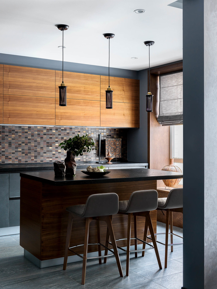 Mid-sized contemporary l-shaped open plan kitchen in Moscow with flat-panel cabinets, grey cabinets, granite benchtops, porcelain splashback, porcelain floors, with island, grey floor and black benchtop.