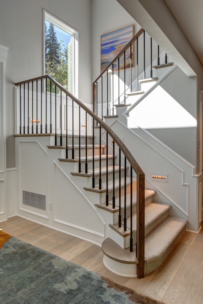 Inspiration for a large transitional wood u-shaped staircase in Seattle with wood risers, mixed railing and decorative wall panelling.
