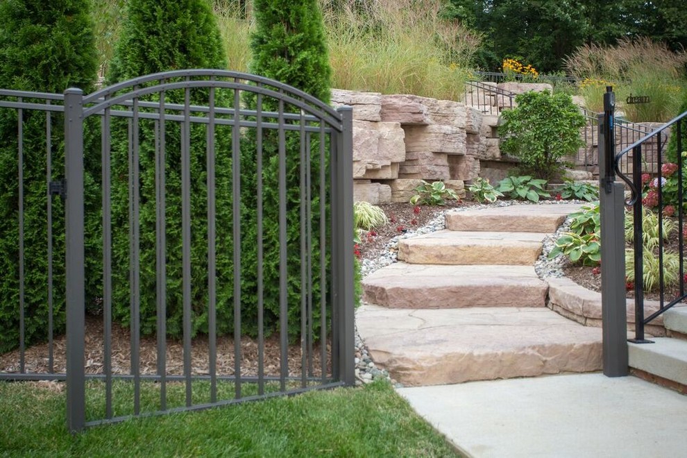 Photo of a mid-sized transitional full sun backyard stone landscaping in Chicago.