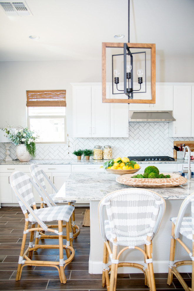 Open concept kitchen - mid-sized transitional u-shaped ceramic tile and brown floor open concept kitchen idea in Phoenix with a single-bowl sink, shaker cabinets, white cabinets, granite countertops, white backsplash, subway tile backsplash, stainless steel appliances and an island