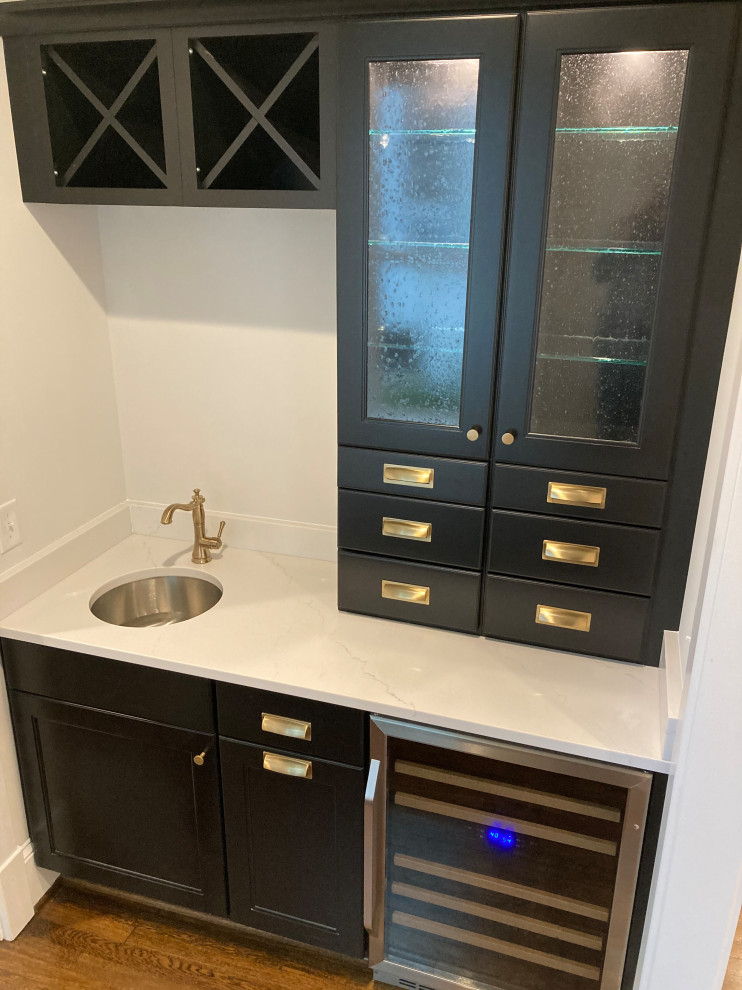 Photo of a mid-sized transitional galley wet bar in DC Metro with an undermount sink, shaker cabinets, black cabinets, quartz benchtops, dark hardwood floors and multi-coloured benchtop.