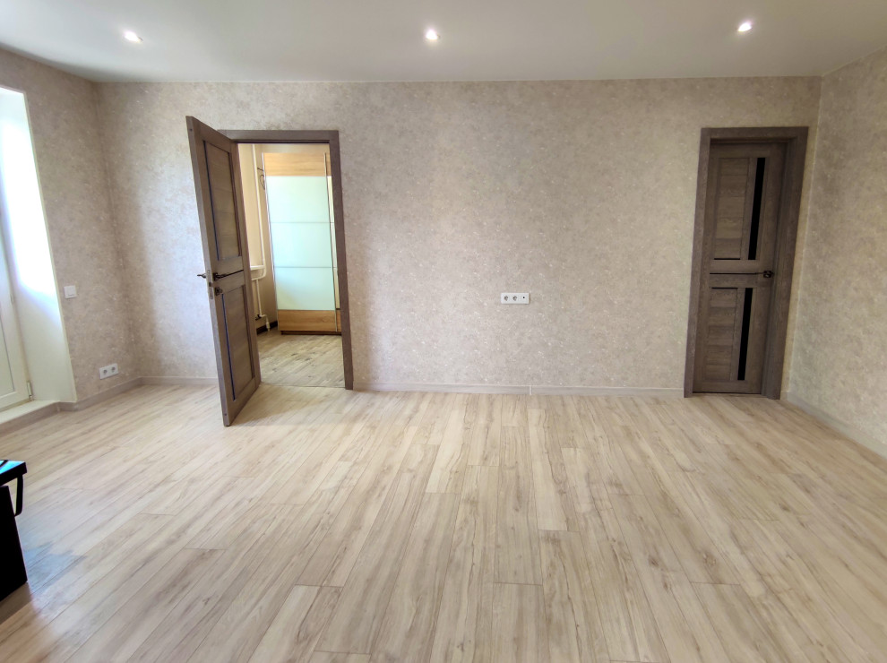 Свежая идея для дизайна: большая гостиная комната с коричневыми стенами, полом из ламината, обоями на стенах и бежевым полом - отличное фото интерьера