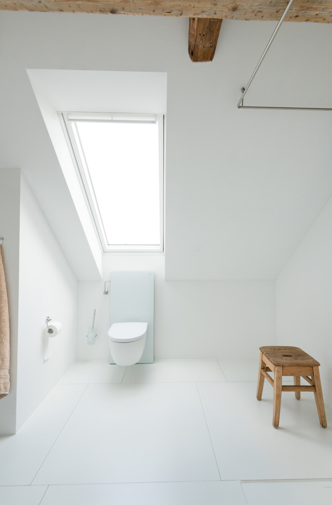 This is an example of a mid-sized scandinavian bathroom in Dortmund with a wall-mount toilet, white tile and white walls.