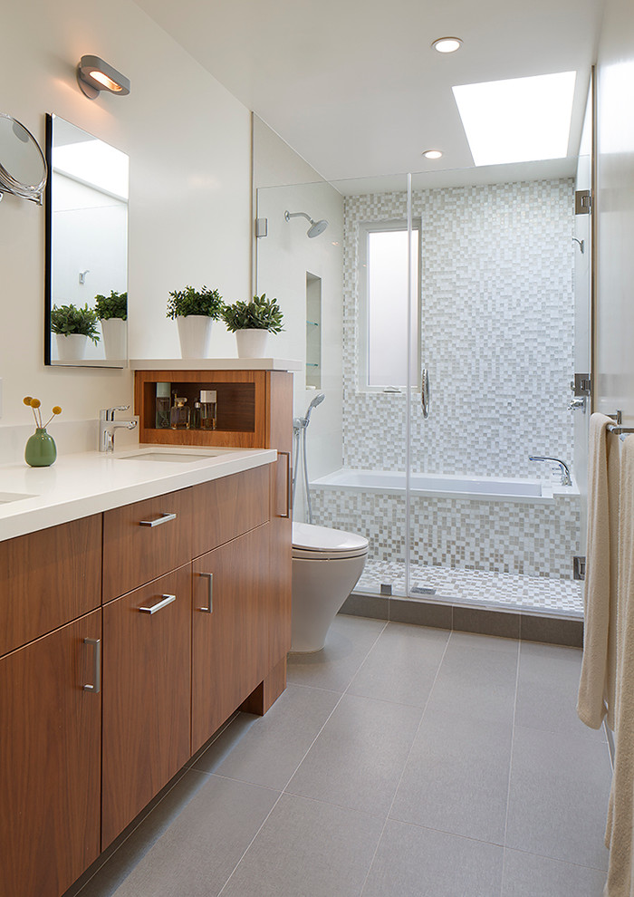 Inspiration for a contemporary bathroom in San Francisco with a drop-in tub, an alcove shower, flat-panel cabinets, medium wood cabinets, engineered quartz benchtops, white tile and mosaic tile.