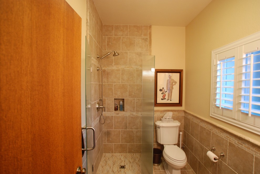Corner shower - small modern 3/4 beige tile and porcelain tile porcelain tile corner shower idea in Orange County with an undermount sink, raised-panel cabinets, dark wood cabinets, granite countertops, a two-piece toilet and beige walls