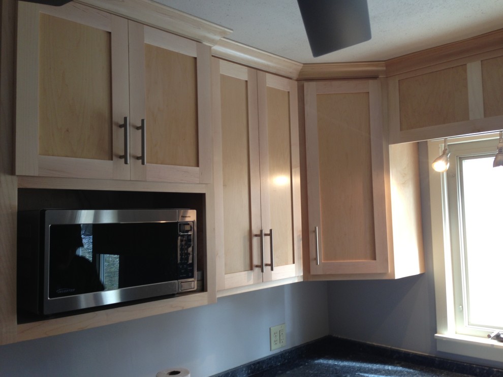 Enclosed kitchen - small transitional u-shaped medium tone wood floor enclosed kitchen idea in Chicago with a double-bowl sink, shaker cabinets, light wood cabinets, quartzite countertops, stainless steel appliances and a peninsula