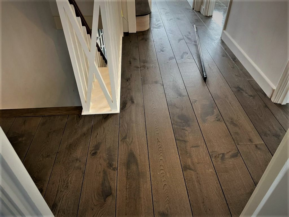 This is an example of a mid-sized traditional hallway in Hertfordshire with beige walls, dark hardwood floors and brown floor.