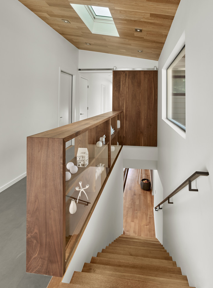 This is an example of a mid-sized midcentury hallway in San Francisco with white walls and concrete floors.