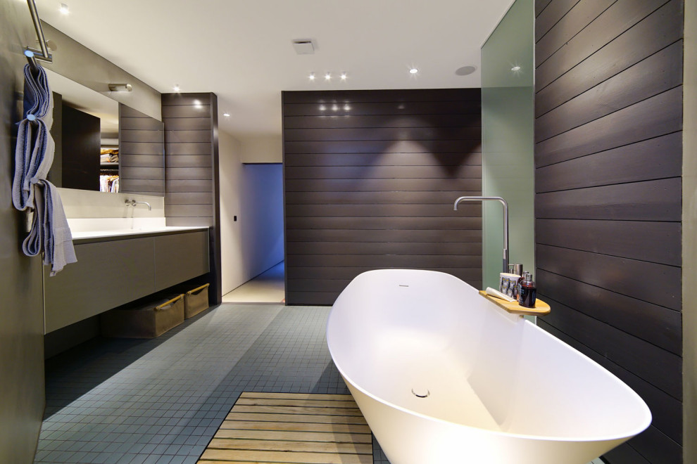 Photo of an expansive contemporary master bathroom in London with flat-panel cabinets, grey cabinets, gray tile, porcelain tile, beige walls, porcelain floors, grey floor and white benchtops.