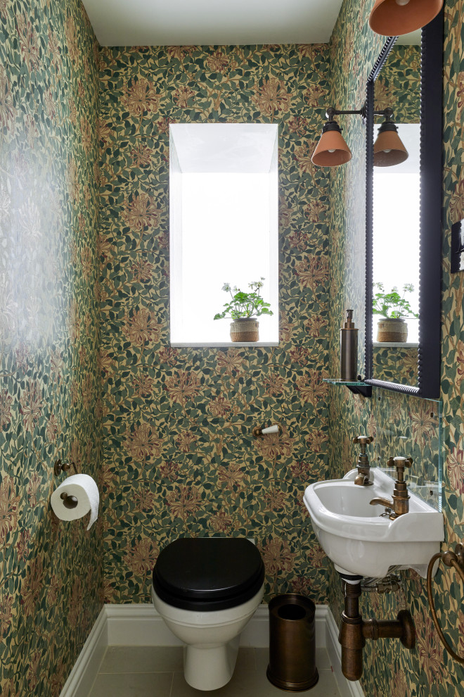 Inspiration for a small traditional cloakroom in London with a wall mounted toilet, porcelain flooring, a wall-mounted sink, beige floors, a feature wall, a floating vanity unit and wallpapered walls.
