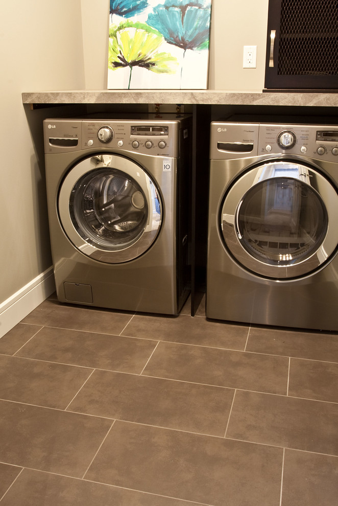Photo of a mid-sized transitional dedicated laundry room in Calgary with grey walls, ceramic floors and a side-by-side washer and dryer.