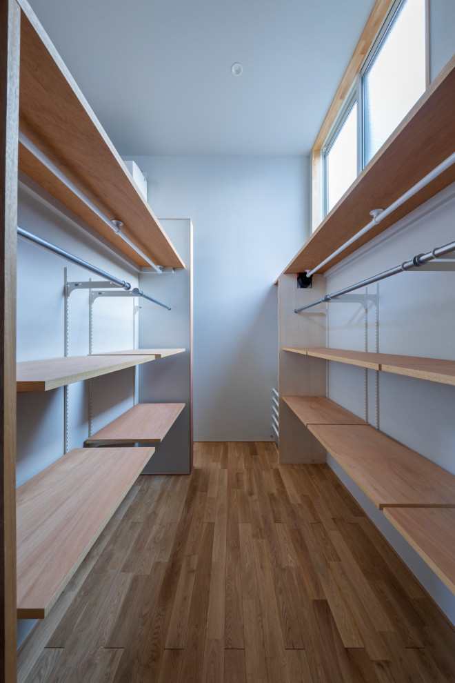 東京都下にある中くらいなコンテンポラリースタイルのおしゃれなウォークインクローゼット (オープンシェルフ、中間色木目調キャビネット、無垢フローリング、ベージュの床、クロスの天井) の写真