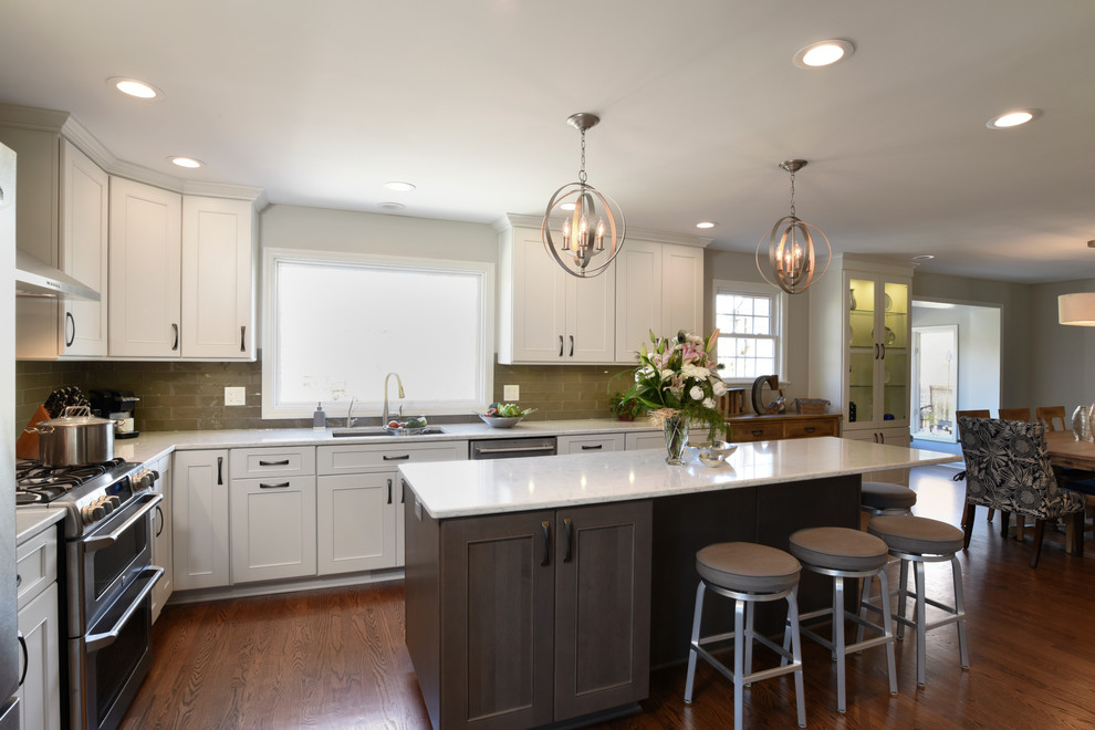 Transitional l-shaped medium tone wood floor eat-in kitchen photo in Orange County with a double-bowl sink, shaker cabinets, white cabinets, marble countertops, gray backsplash, glass tile backsplash, stainless steel appliances and an island