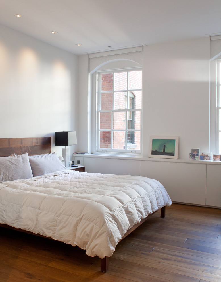 Design ideas for a modern bedroom in New York with white walls and dark hardwood floors.