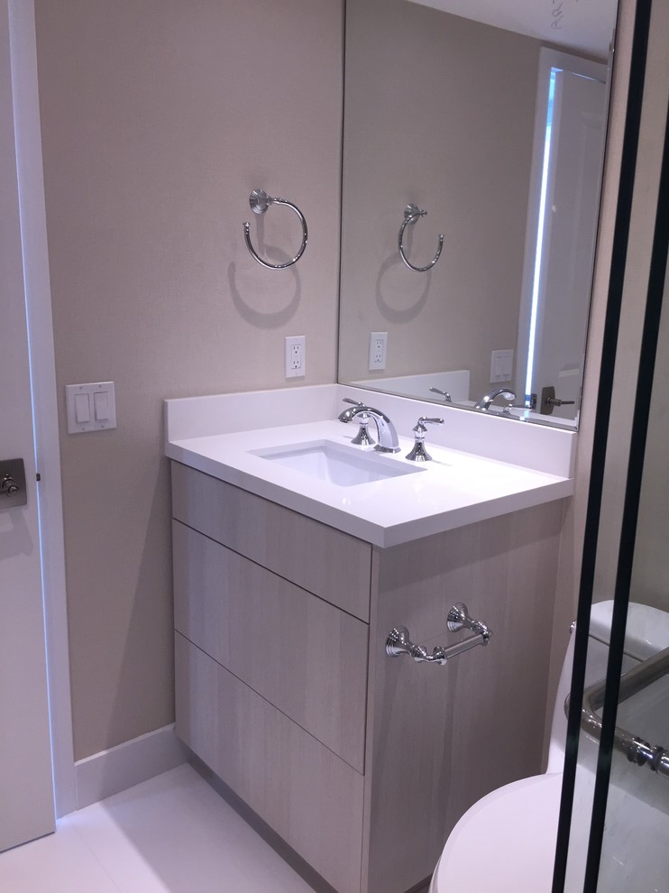 Inspiration for a mid-sized contemporary kids bathroom in Miami with flat-panel cabinets, light wood cabinets, an alcove shower, a one-piece toilet, beige tile, glass tile, beige walls, an undermount sink and quartzite benchtops.