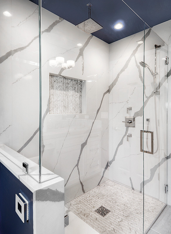 Photo of a mid-sized transitional master bathroom in San Francisco with recessed-panel cabinets, white cabinets, a curbless shower, a one-piece toilet, white tile, blue walls, ceramic floors, an undermount sink, engineered quartz benchtops and stone slab.