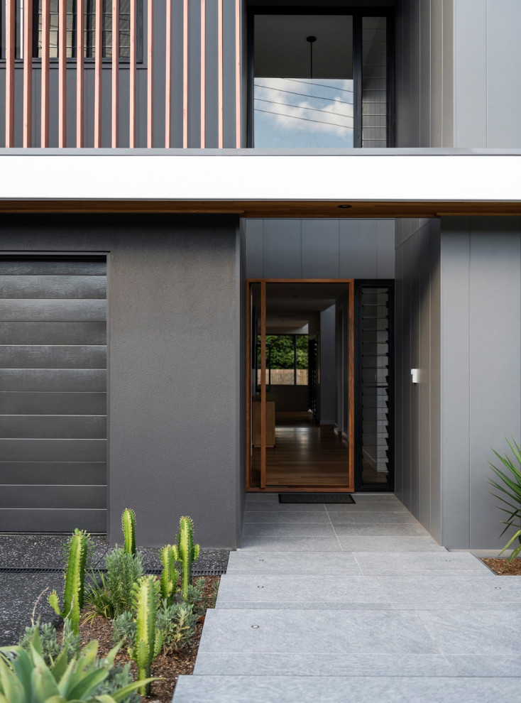 Contemporary two-storey grey house exterior with a hip roof and a metal roof.