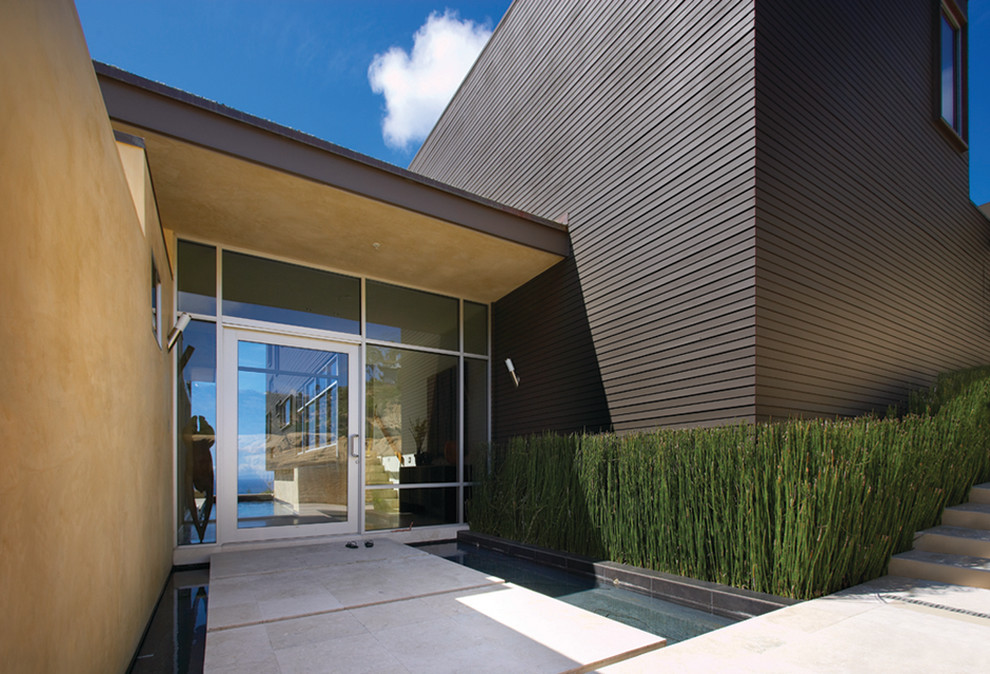 This is an example of a modern entryway in Los Angeles with a single front door and a glass front door.