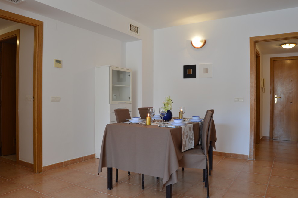 Modelo de comedor tradicional renovado de tamaño medio abierto sin chimenea con paredes blancas y suelo de baldosas de cerámica