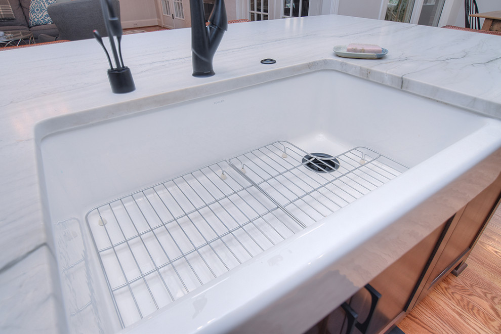 Inspiration for a huge transitional light wood floor open concept kitchen remodel in Charlotte with a farmhouse sink, shaker cabinets, medium tone wood cabinets, quartzite countertops, an island and white countertops