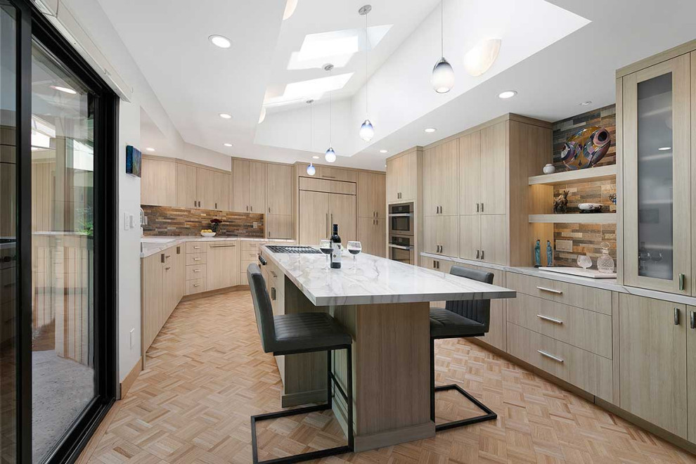 Modern inredning av ett stort vit vitt kök, med en undermonterad diskho, släta luckor, skåp i ljust trä, flerfärgad stänkskydd, stänkskydd i stenkakel, integrerade vitvaror, plywoodgolv, en köksö och beiget golv