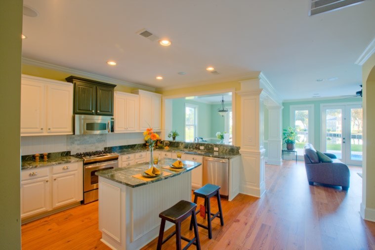 Mid-sized traditional l-shaped kitchen in Atlanta with white cabinets, stainless steel appliances and with island.