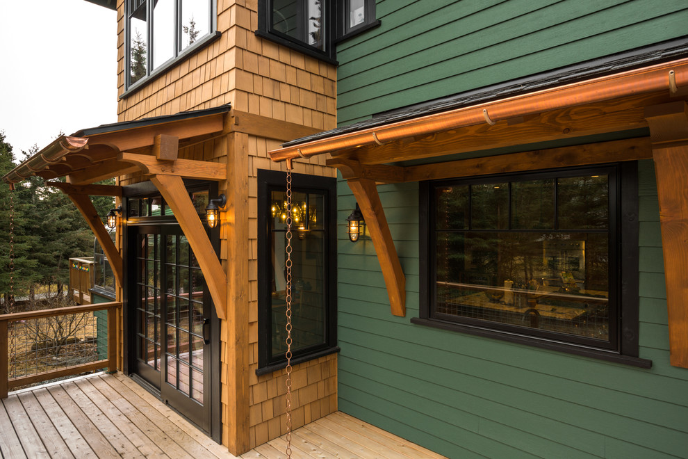 Example of a mid-sized mountain style backyard deck design with an awning