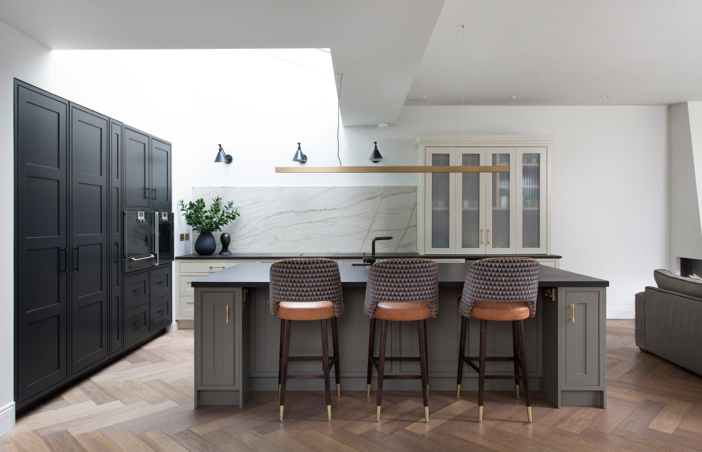 This is an example of a contemporary kitchen in Other with a single-bowl sink, black cabinets, quartz benchtops, green splashback, marble splashback, with island, brown floor and black benchtop.