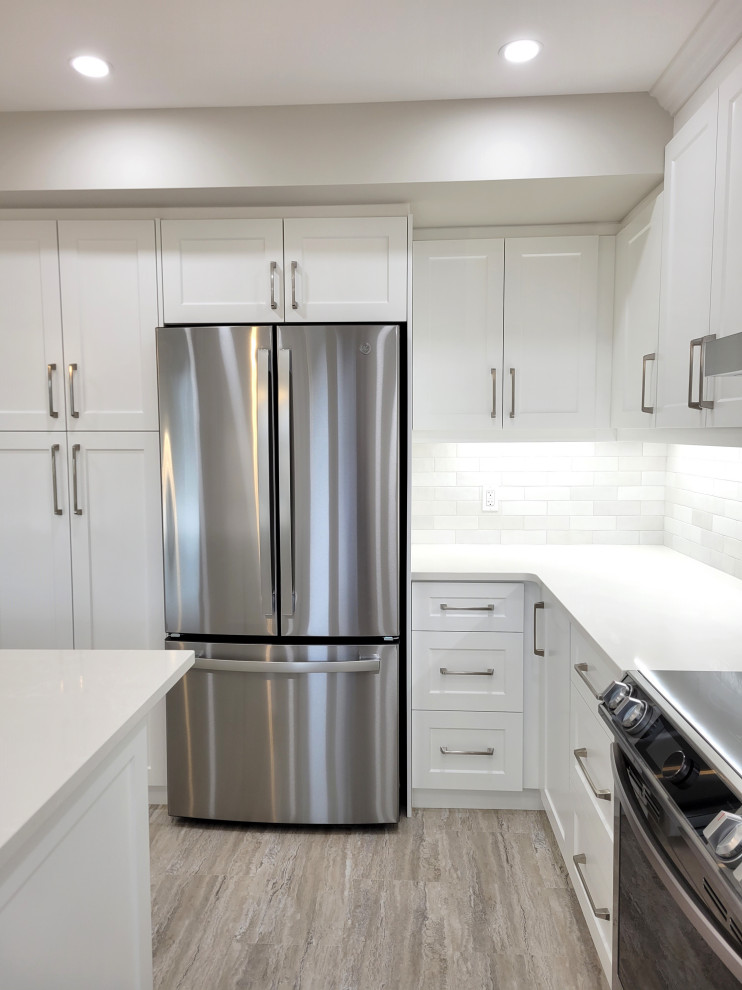 Inspiration for a huge transitional u-shaped vinyl floor and multicolored floor eat-in kitchen remodel with an undermount sink, white cabinets, quartzite countertops, gray backsplash, stone tile backsplash, stainless steel appliances, an island and white countertops