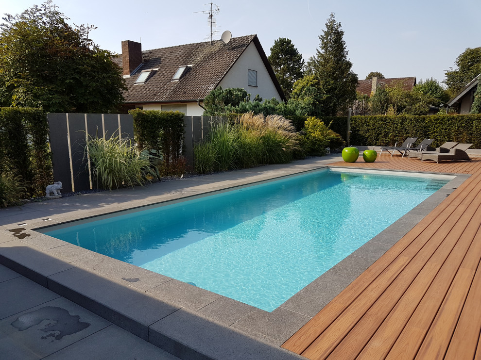 Photo of a large mediterranean side yard rectangular pool in Frankfurt with natural stone pavers.