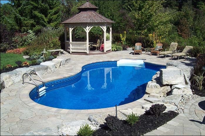 Example of a mid-sized transitional backyard concrete paver and custom-shaped lap pool design in Toronto
