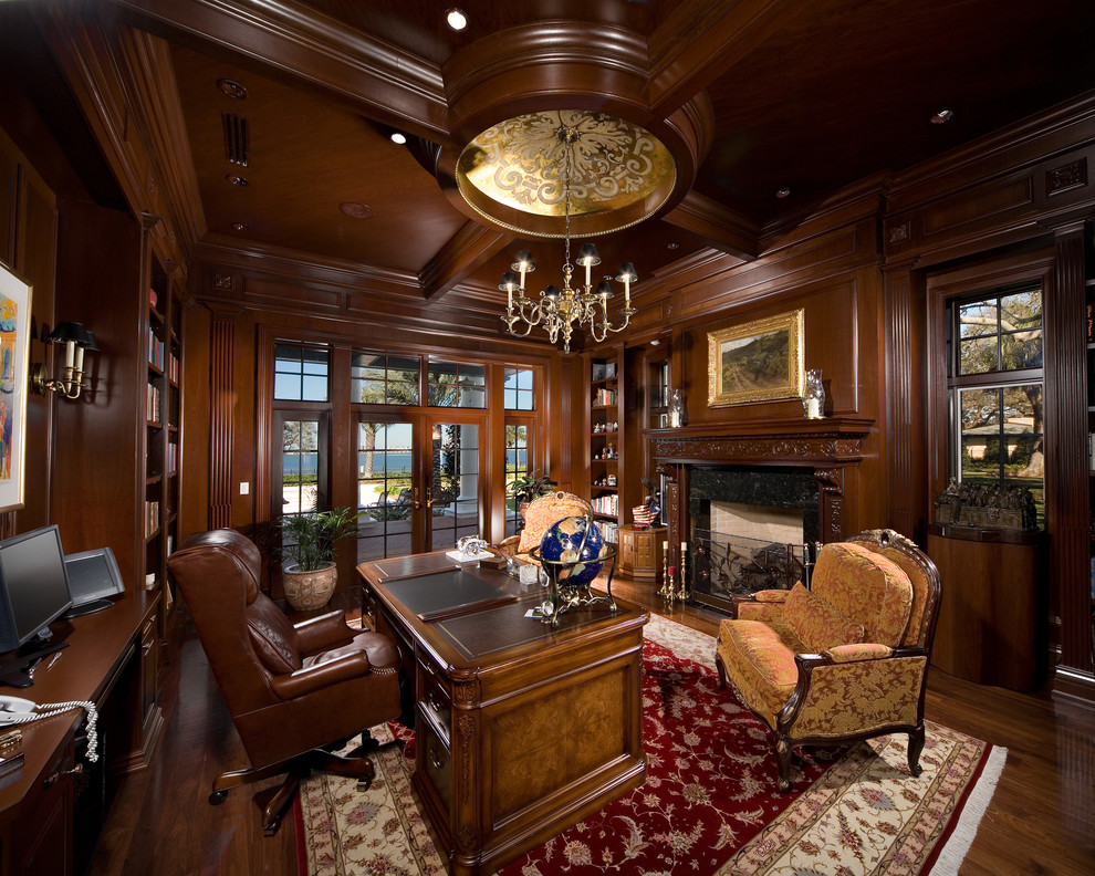 Large traditional home office in Tampa with dark hardwood floors, a standard fireplace and a freestanding desk.