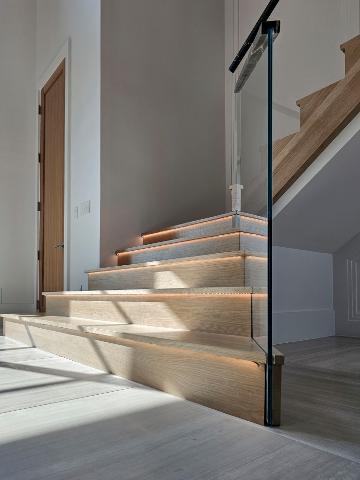 Пример оригинального дизайна: огромная деревянная лестница на больцах в современном стиле с деревянными ступенями, перилами из смешанных материалов и панелями на стенах