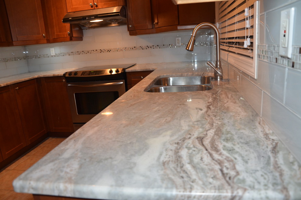 Inspiration for a small transitional u-shaped porcelain tile enclosed kitchen remodel in Toronto with a double-bowl sink, beaded inset cabinets, medium tone wood cabinets, granite countertops, white backsplash, glass tile backsplash, stainless steel appliances and no island