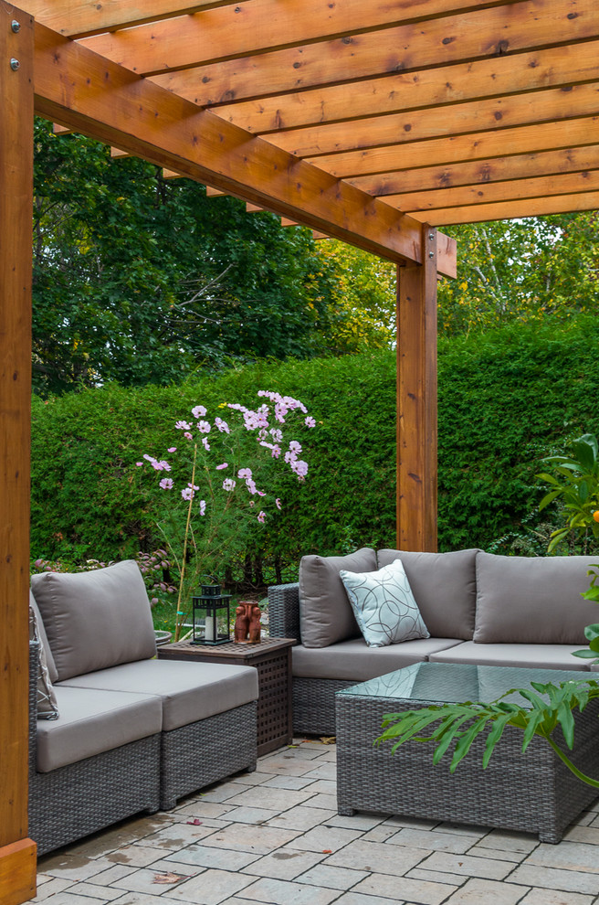 Inspiration for a mid-sized contemporary backyard stone patio remodel in Toronto with a pergola